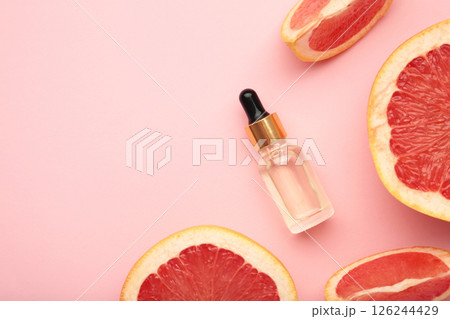Bottle of essential oil and fresh grapefruits on pink background Bottle of essential oil and fresh grapefruits on pink background 126244429