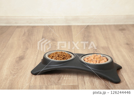 Wet food for dogs and cats in silver bowl on floor kitchen tiles background. 126244446