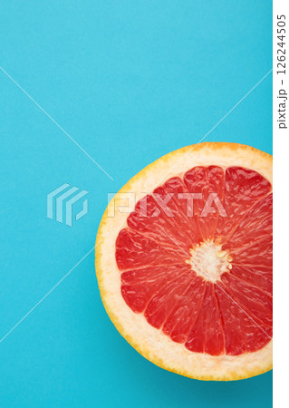 Half of fresh grapefruit on a blue background. Vertical photo 126244505