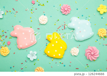 Tasty Easter cookies in shape on bunny and candies on mint background Tasty Easter cookies in shape on bunny and candies on mint background 126244666