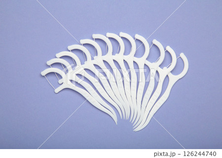 Floss toothpick on purple background. Dental hygiene concept. Floss toothpick on purple background. Dental hygiene concept. 126244740