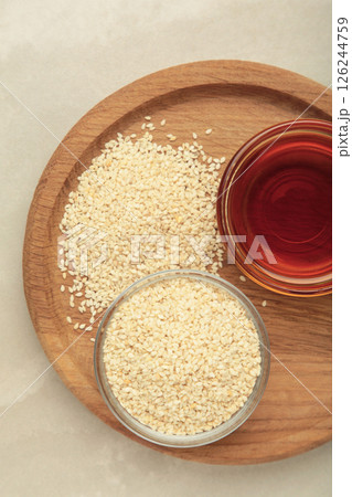 Sesame seeds and sesame oil on light background Sesame seeds and sesame oil on light background 126244759