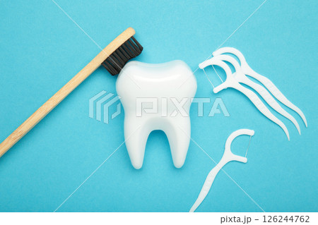 Dental floss and toothbrushes on blue background. Care of teeth health. Everyday routine teeth cleaning and flossing. Top view Dental floss and toothbrushes on blue background. Care of teeth health. Everyday routine teeth cleaning and flossing. Top view 126244762