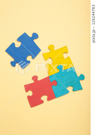 Colorful puzzle on beige background. Multi-colored heart as a symbol of World Autism Awareness Day. Top view 126244763