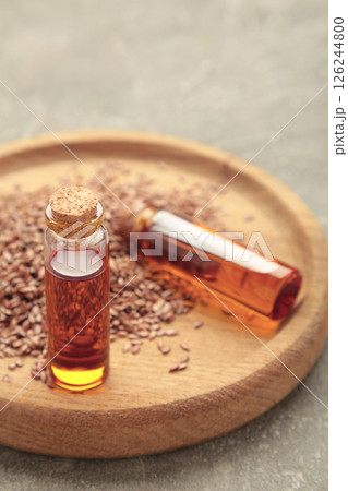 Flaxseeds with flaxseed oil in glass bottle on grey concrete background. Vertical photo Flaxseeds with flaxseed oil in glass bottle on grey concrete background. Vertical photo 126244800