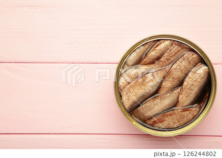 Opened can with sprats in oil on a wooden pink background 126244802