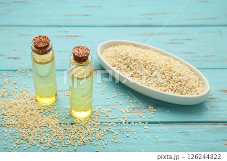 Flaxseeds with flaxseed oil in glass bottle on blue wooden background. Flaxseeds with flaxseed oil in glass bottle on blue wooden background. 126244822