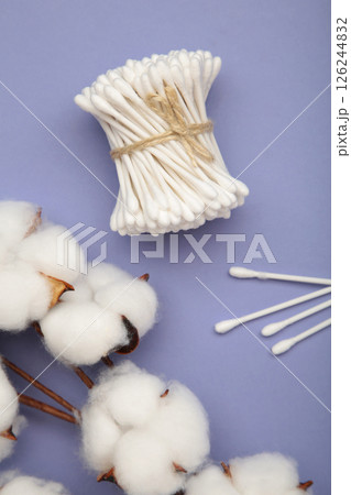White cotton stricks on purple textured background. Eco friendly. Hygienic cotton swabs for ears. Top view 126244832