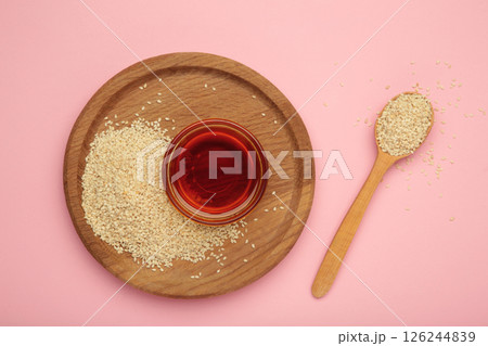 Sesame seeds and sesame oil isolated on pink background 126244839