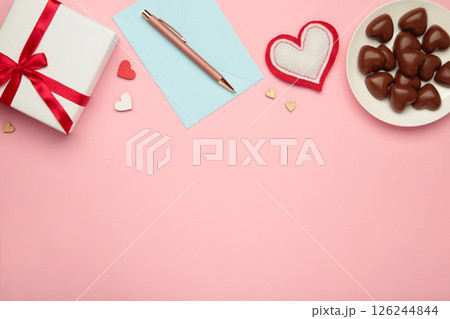 Valentine's day greeting card with gift, hearts chocolate sweets and letter on pink background. Valentine's day greeting card with gift, hearts chocolate sweets and letter on pink background. 126244844
