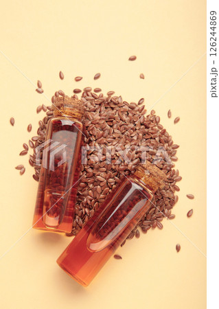 Flaxseeds with flaxseed oil in glass bottle on beige background. 126244869