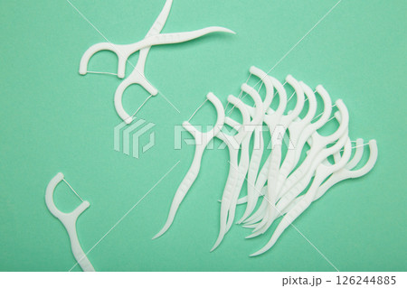 Floss toothpick on mint background. Dental hygiene concept. 126244885