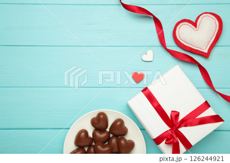 Valentine's day greeting card with gift, hearts chocolate sweets and letter on blue wooden background. Valentine's day greeting card with gift, hearts chocolate sweets and letter on blue wooden background. 126244921