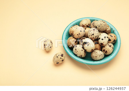 Quail eggs in bowl on beige background. Quail eggs in bowl on beige background. 126244937
