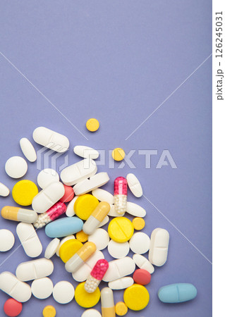 Various colored pills on purple background. Space for text Various colored pills on purple background. Space for text 126245031