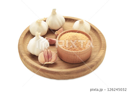 Garlic powder on wooden bowl with garlic isolated on white background, top view Garlic powder on wooden bowl with garlic isolated on white background, top view 126245032