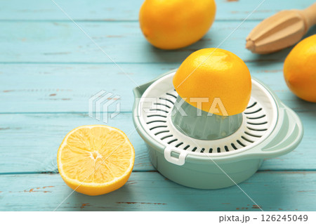 Squeezer and lemons on blue wooden background Squeezer and lemons on blue wooden background 126245049