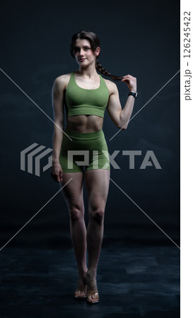 Young beautiful woman with athletic body on dark background. Fitness girl Young beautiful woman with athletic body on dark background. Fitness girl 126245422