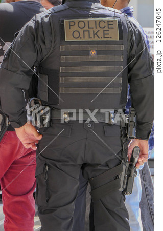 Greece, Thessaloniki, police officer seen from behind with his hand on his weapon Greece, Thessaloniki, police officer seen from behind with his hand on his weapon 126247045