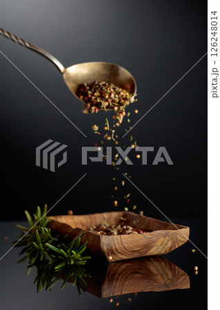 Fresh rosemary and dried spices on a black background. 126248014