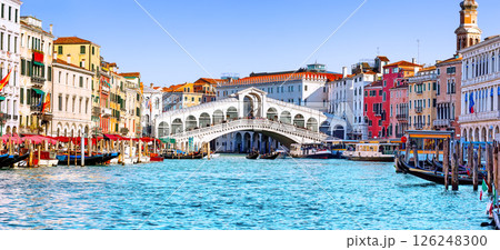 Panoramic view of Grand Canal with Rialto Bridge and gondoliers in Venice, Italy. Panorama of Rialto Bridge and gondola on the Grand Canal in Venice, Italy. Panoramic view of Grand Canal with Rialto Bridge and gondoliers in Venice, Italy. Panorama of Rialto Bridge and gondola on the Grand Canal in Venice, Italy. 126248300