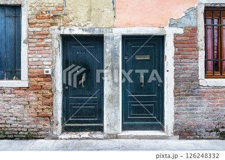Ancient wooden door in old stone home wall in Venice. Italy. Old blue wooden doors in an ancient Venetian house in Venice, Italy. Ancient wooden door in old stone home wall in Venice. Italy. Old blue wooden doors in an ancient Venetian house in Venice, Italy. 126248332