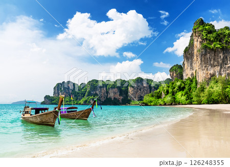 Thai traditional wooden longtail boat on tropical beach with limestone rock, Railay Beach in Krabi province., Thailand. 126248355