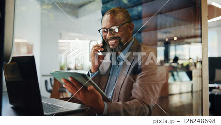 Laptop, phone call and tablet with business black man in pod for communication or update. App, computer and conversation with mature employee in cubicle for accounting, feedback or hybrid work Laptop, phone call and tablet with business black man in pod for communication or update. App, computer and conversation with mature employee in cubicle for accounting, feedback or hybrid work 126248698