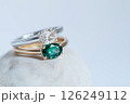 Elegant diamond and emerald rings displayed on a soft white background. Beautiful rings with diamond and emerald stones, showcasing exquisite craftsmanship on a white textured setting. 126249112