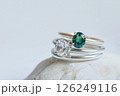 Elegant diamond and emerald rings displayed on a soft white background. Beautiful rings with diamond and emerald stones, showcasing exquisite craftsmanship on a white textured setting. 126249116
