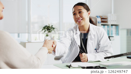 Doctor, senior woman and smile with handshake at clinic for introduction, thanks or healthcare service. People, elderly patient and shaking hands for hello, happy or welcome to consulting at hospital 126249747