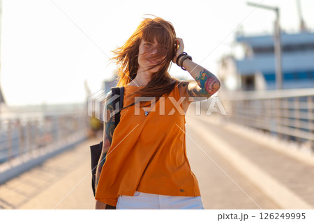 Summer vacation. Portrait of young smiling happy Caucasian woman with tattoo. Concept of freedom and happiness 126249995