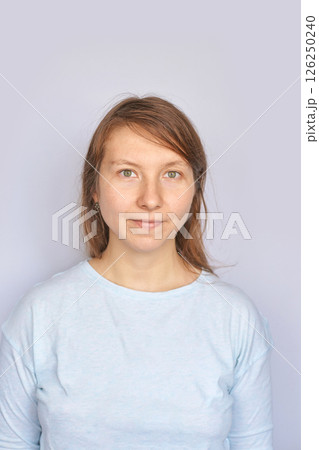 Young caucasian female in light blue shirt against plain background Young caucasian female in light blue shirt against plain background 126250240