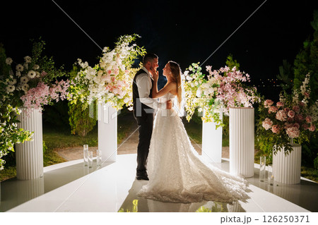 Bride and groom in the night area for the wedding ceremony with flowers. Bride and groom in the night area for the wedding ceremony with flowers. 126250371
