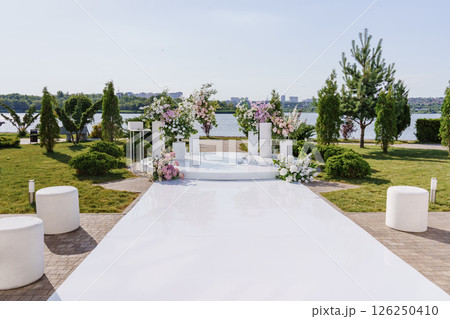 a path to the area of a wedding ceremony on the banks with columns and flowers. 126250410