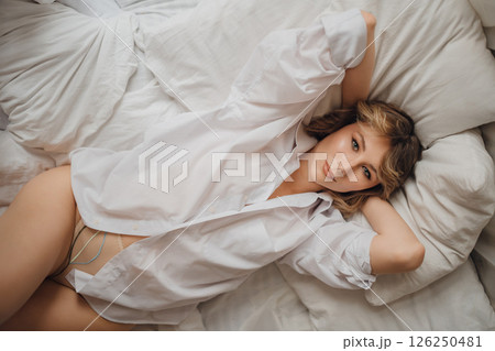 sexy woman in white shirt in bed. female attractiveness and sexuality. top view 126250481