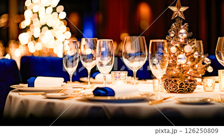 Still life served festive dinner table while Christmas lights glowing 126250809