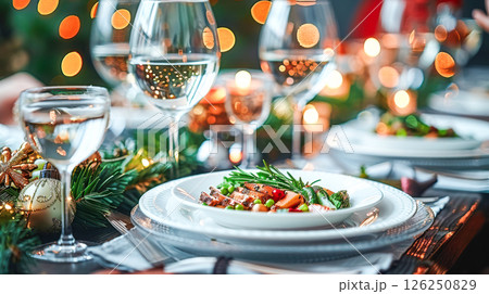 Still life served festive dinner table while Christmas lights glowing 126250829