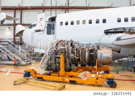 Passenger airplane near to high-bypass turbofan aircraft engine in aviation hangar Passenger airplane near to high-bypass turbofan aircraft engine in aviation hangar 126251441