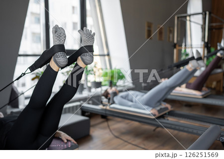 A detailed closeup of a foot work and core exercise on a Balanced Body Reformer machine illuminated by sunlight A detailed closeup of a foot work and core exercise on a Balanced Body Reformer machine illuminated by sunlight 126251569