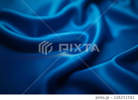Soft satin fabric flows gracefully, showcasing a deep blue hue that glimmers under gentle light. The luxurious texture invites touch and evokes a sense of calmness Generative AI 126251581