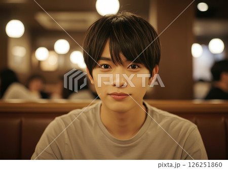 カフェでカメラ目線で微笑む若い男性のポートレート（AI生成画像） 126251860