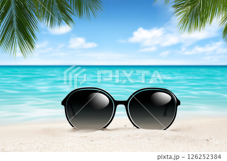 Sunglasses resting on sandy beach with tropical ocean view 126252384
