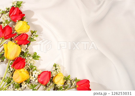 Abstract floral arrangement with beautiful spring blooming tulips and cherry blossom branches on elegant sunny background. Still life with space for text, Floral holiday card with summer greeting Abstract floral arrangement with beautiful spring blooming tulips and cherry blossom branches on elegant sunny background. Still life with space for text, Floral holiday card with summer greeting 126253031