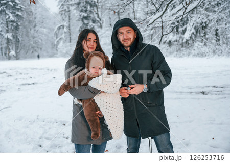 Parents with little son is in the winter park together 126253716