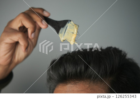 Applying hair product with a spatula for a stylish look 126255343