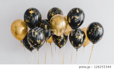 Elegant black and gold balloons with metallic accents on gray background. 126255344