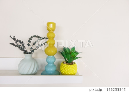 Colorful home decor arrangement on a shelf in a modern interior 126255545
