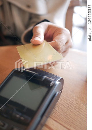 Customer making a payment with card at a cafe in the morning Customer making a payment with card at a cafe in the morning 126255588