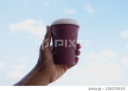 Enjoying a warm drink against a clear blue sky backdrop 126255610